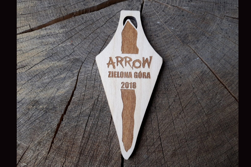 Opcja 1 (opisowa): Drewniany medal pamiątkowy Arrow Zielona Góra 2018 z grawerem logotypu i datą wydarzenia.