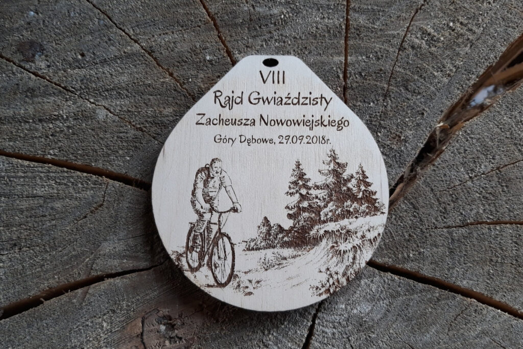 Drewniany medal na VIII Rajd Gwieździsty im. Zachariasza Nowowiejskiego z grawerem rowerzysty
