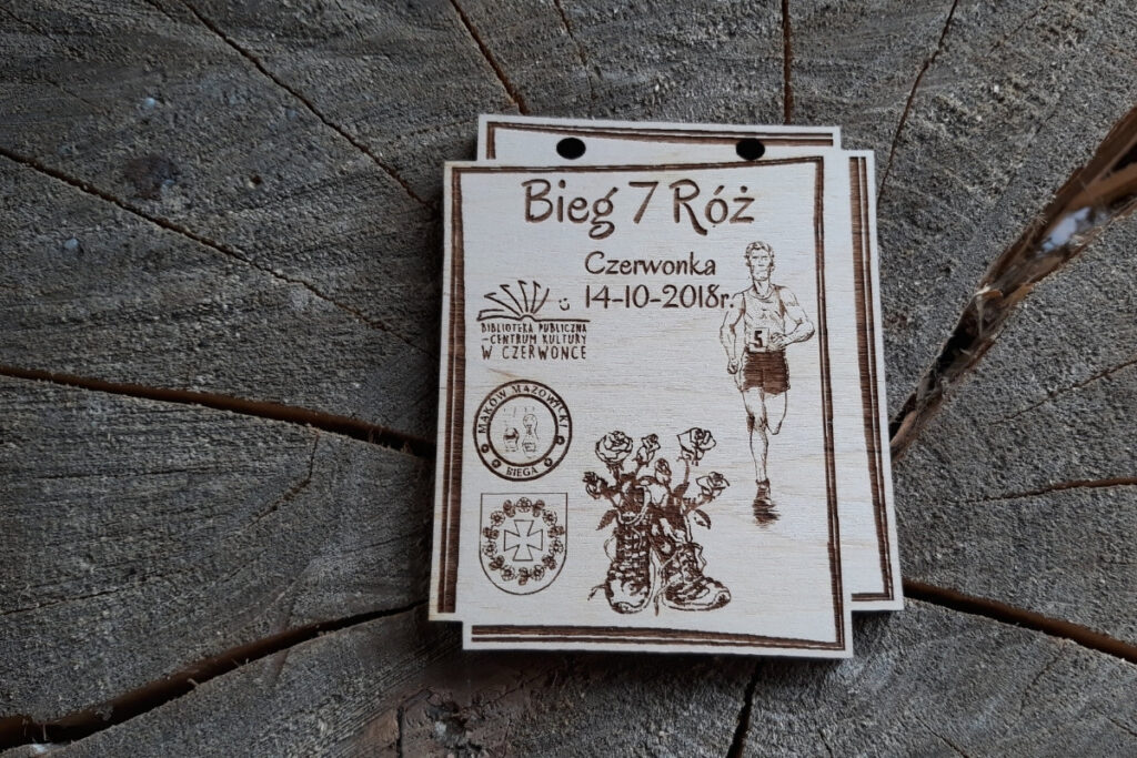 Drewniany medal na Bieg 7 Róż Czerwonka 2018 z grawerem róży, biegacza i logotypami biegu.