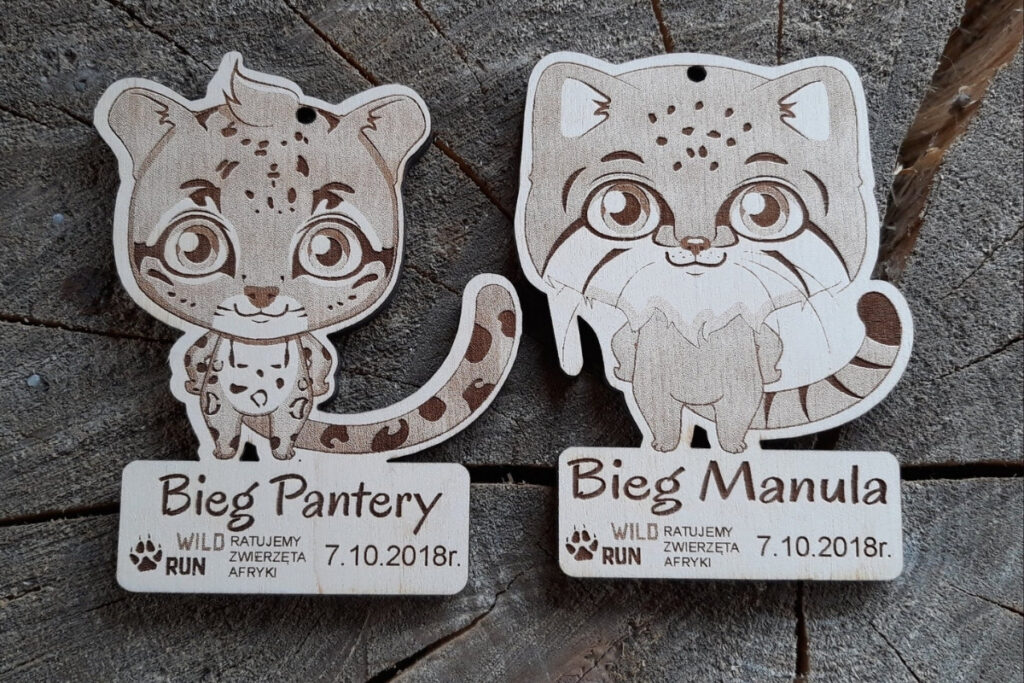 Drewniane medale w kształcie pantery i manula na biegi charytatywne „Ratujemy zwierzęta Afryki”.
