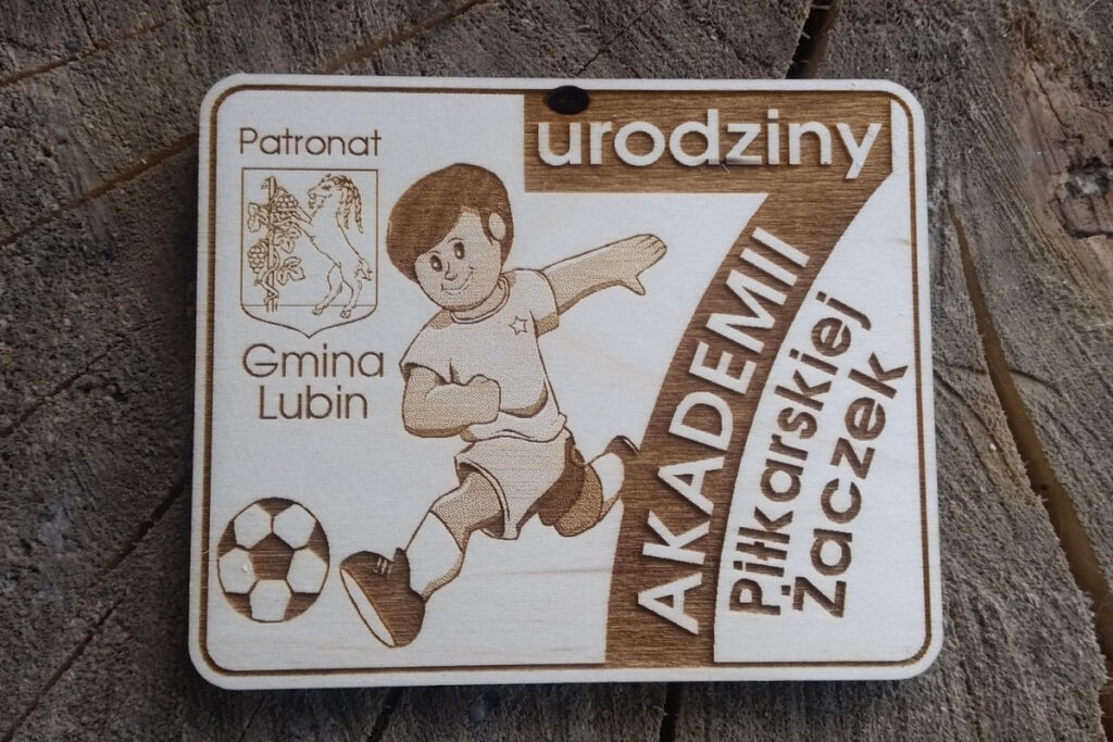Drewniany medal na 7. urodziny Akademii Piłkarskiej Żaczek z grawerem piłki nożnej i logo akademii.