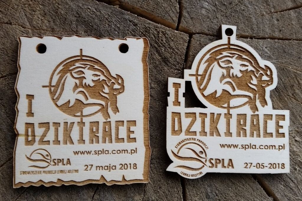 Drewniany medal na I Dziki Race z grawerem głowy dzika i dynamicznym logotypem biegu.