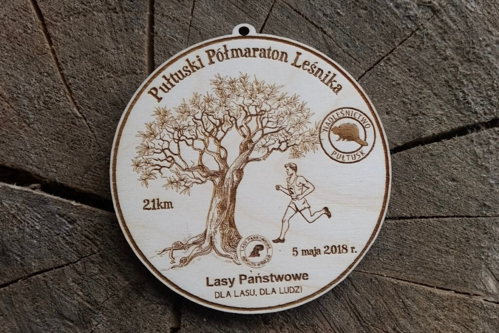 Propozycja drewnianych medali na Pułtuski Półmaraton Leśnika z motywami drzew i biegacza.