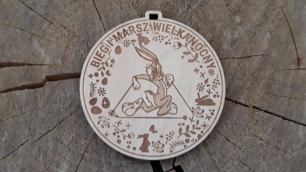 Okrągły drewniany medal na Bieg i Marsz Wielkanocny z grawerem biegnącego zająca oraz personalizacją wydarzenia.