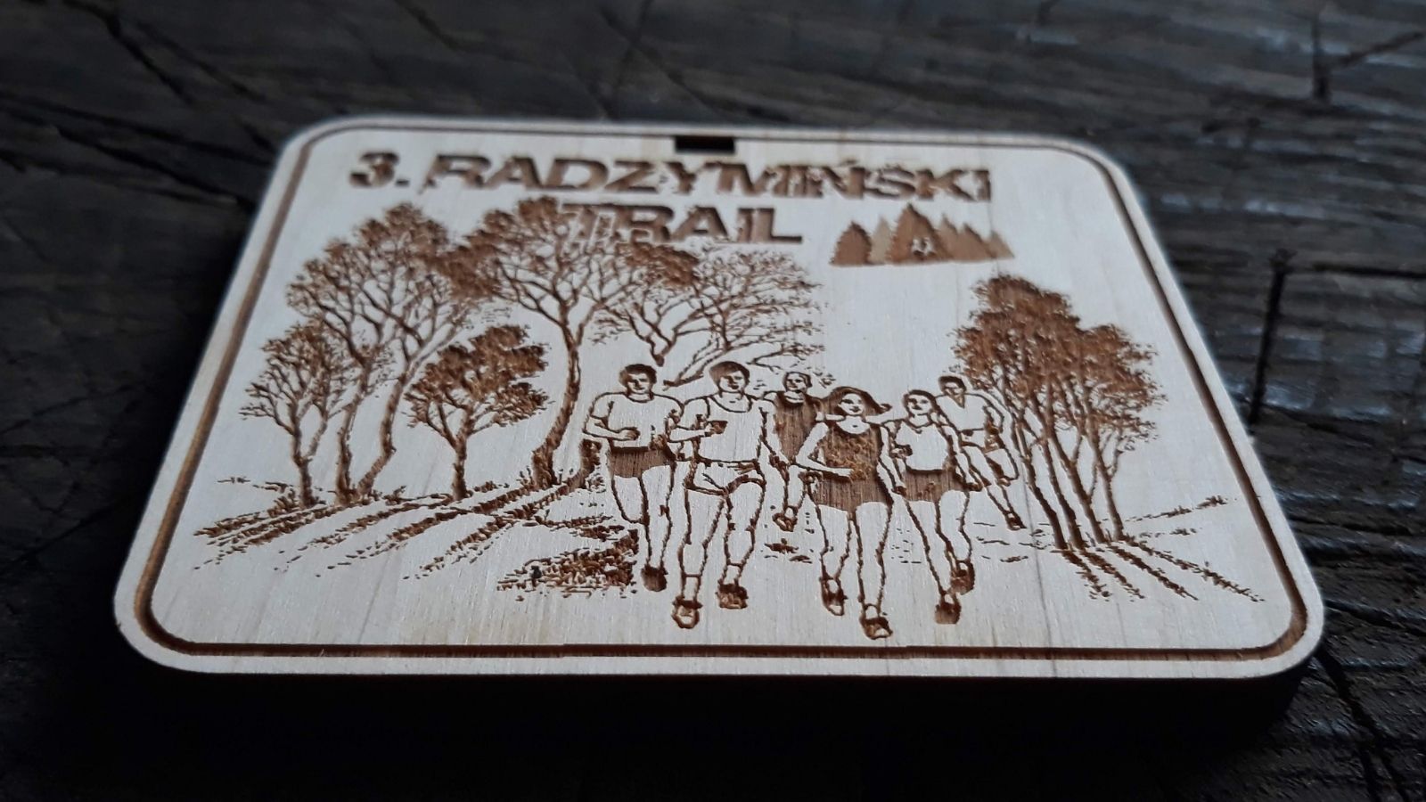 Prostokątny drewniany medal na bieg leśny – biegacze na tle drzew