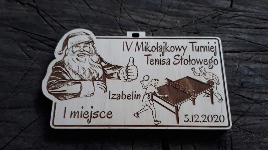 Prostokątny drewniany medal mikołajkowy z grawerem przedstawiającym św. Mikołaja trzymającego kciuk w górze i graczami w tenisa stołowego, przygotowany na turniej świąteczny.