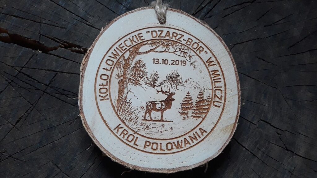 Drewniany medal myśliwski wykonany z naturalnego plastra brzozy z korą, z grawerem przedstawiającym jelenia oraz napisem „Król Polowania – KŁ Darz-Bór w Miliczu”.