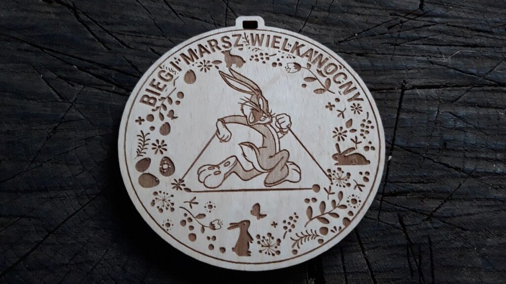Okrągły drewniany medal na Bieg i Marsz Wielkanocny z grawerem biegnącego zająca oraz personalizacją wydarzenia.