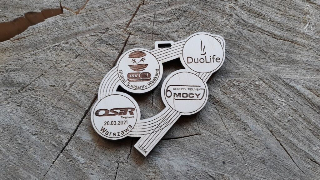 4 logotypy i bieżnia lekkoatletyczna. Drewniany medal ażurowy 4 logotypy i bieżnia lekkoatletyczna. Drewniany medal ażurowy