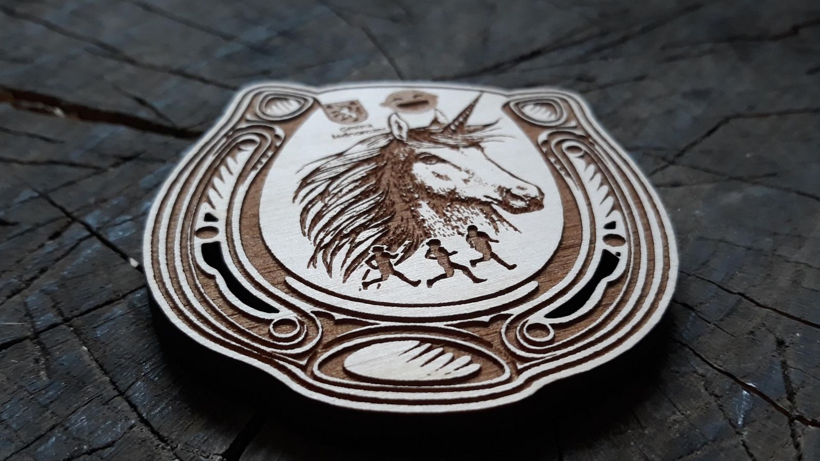 Drewniany medal w kształcie podkowy z Jednorożcem w środku