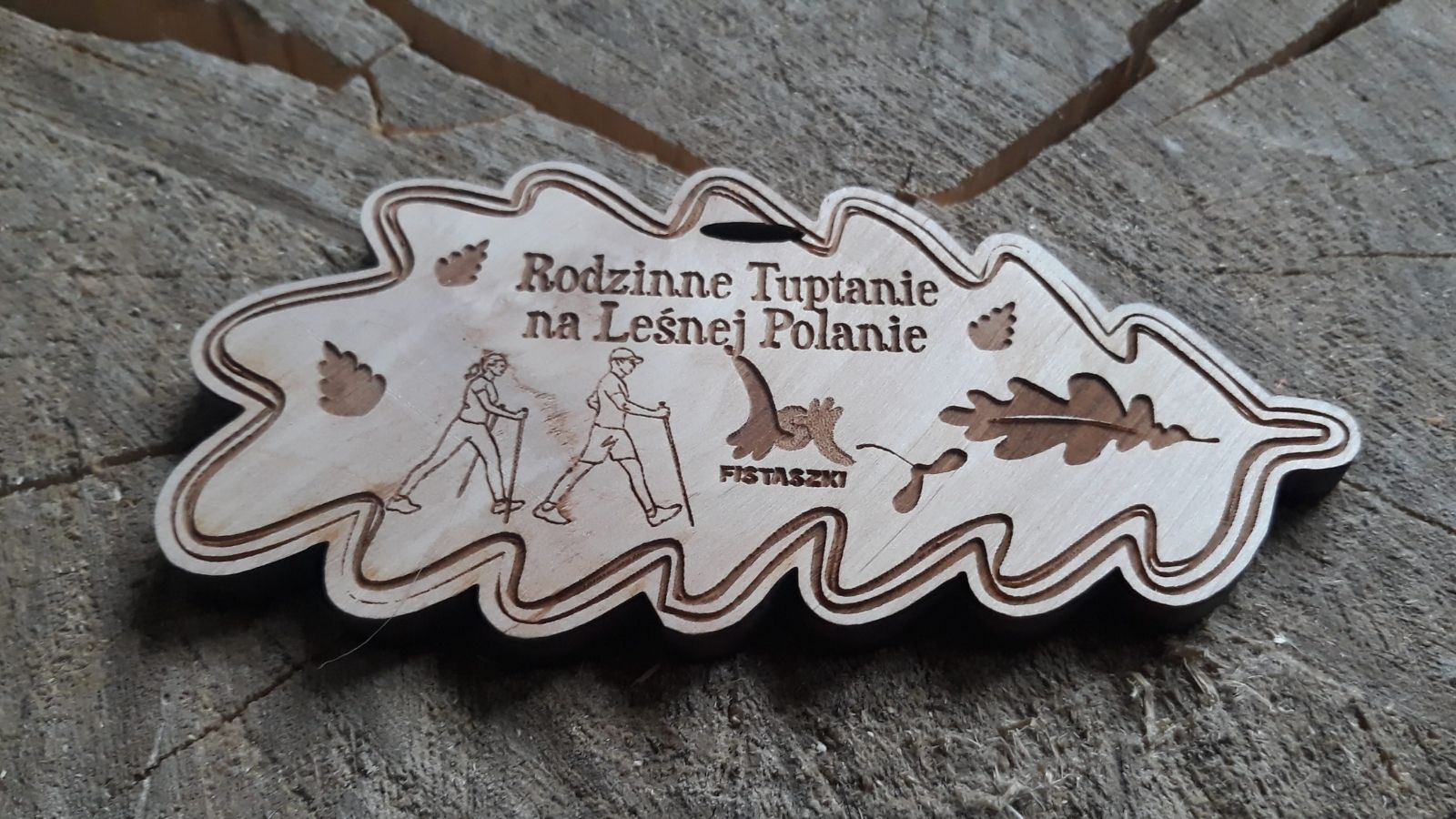 Rodzinne Tuptanie. Drewniany medal w kształcie liścia dębu.
