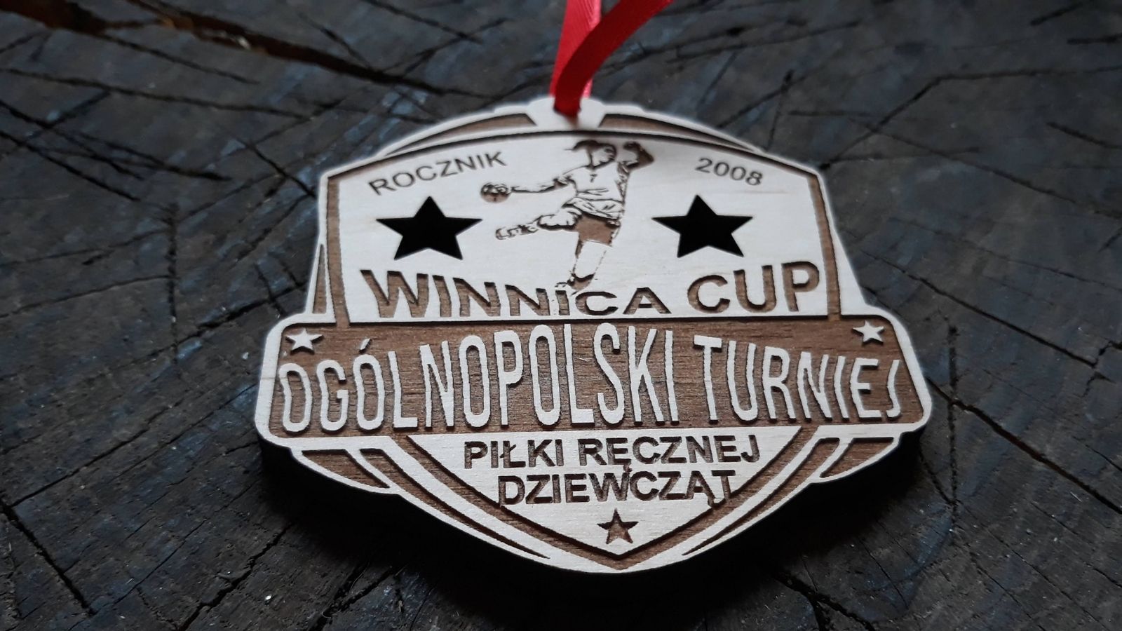 Ogólnopolski Turniej Piłki Ręcznej Dziewcząt. Drewniany medal z ozdobnymi ażurowo wyciętymi gwiazdkami.