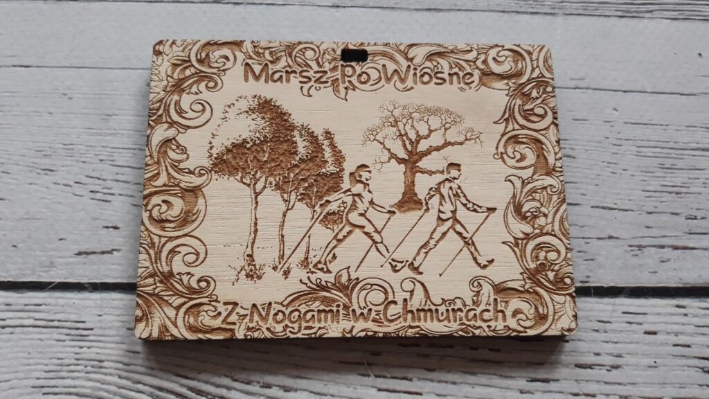 Marsz Po Wiosnę – drewniany medal z ozdobną ramką, drzewami oraz zawodnikami Nordic Walking
