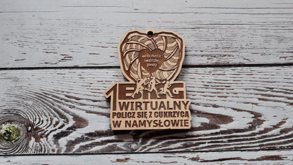 Duży drewniany medal o grubości 6 mm na Bieg Wirtualny „Policz się z cukrzycą” z okazji Finału WOŚP, z grawerowanym charakterystycznym sercem Wielkiej Orkiestry Świątecznej Pomocy, datą Finału oraz sportowymi motywami.