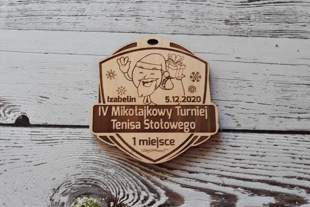 Oryginalny drewniany medal z grawerem uśmiechniętego Świętego Mikołaja na mikołajkowy turniej ping-ponga.