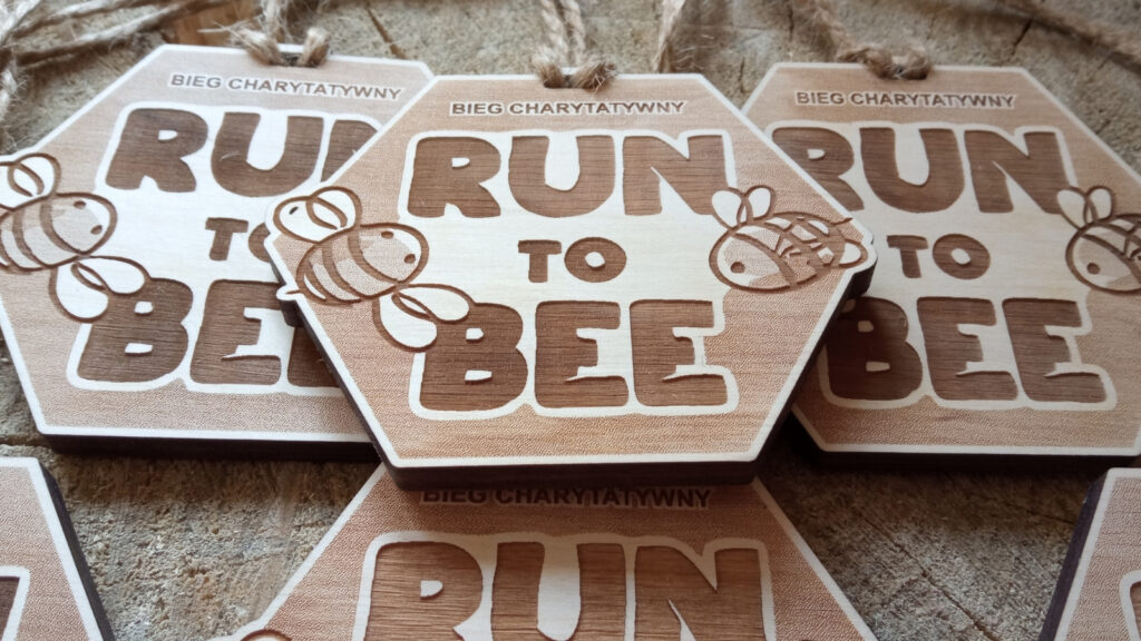 Drewniany medal w kształcie plastra miodu – sześciokąta na bieg charytatywny Run to Bee