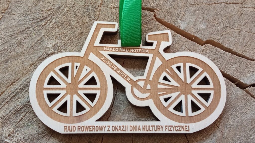 Drewniany medal w kształcie roweru, z ażurowymi wycięciami