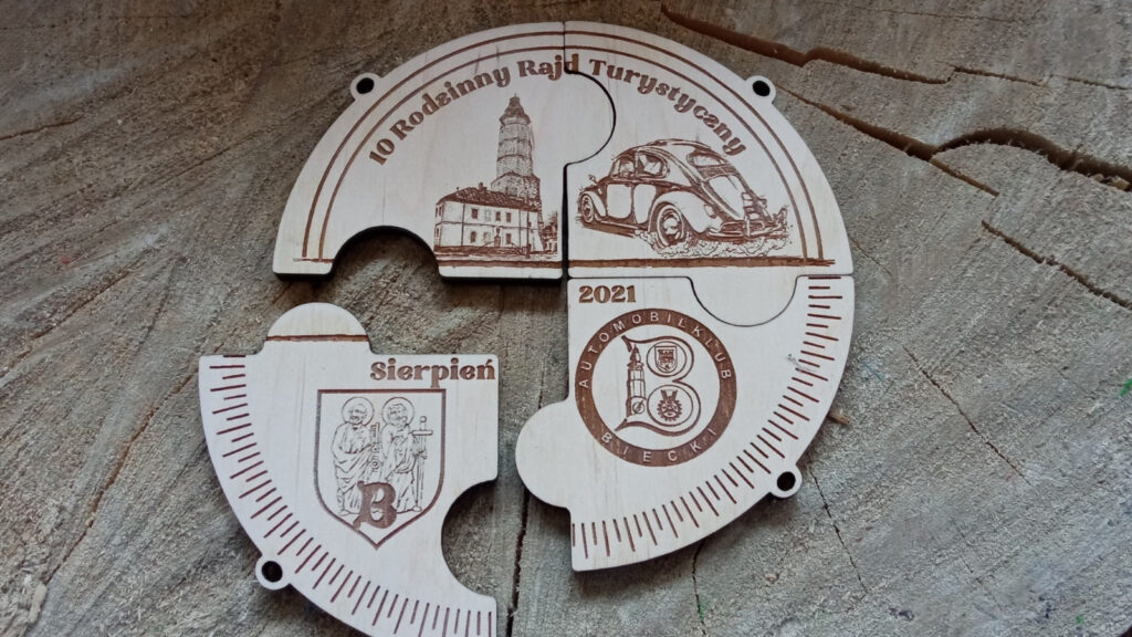 10 Rodzinny Rajd Turystyczny – drewniana tabliczka składająca się z 4 dopasowanych medali na zasadzie puzzla.