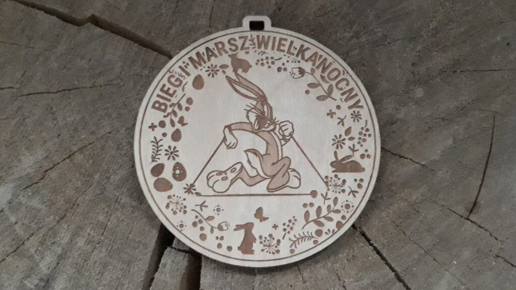 Okrągły drewniany medal na Bieg i Marsz Wielkanocny z grawerem biegnącego zająca oraz personalizacją wydarzenia.