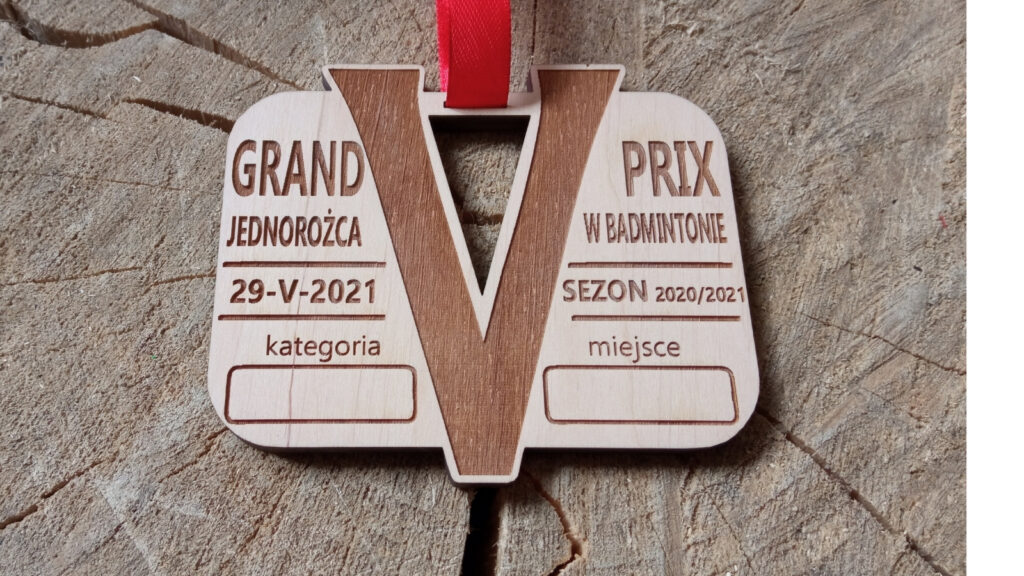 Drewniany medal na V Grand Prix Jednorożca w Badmintonie z grawerem lotki, logotypem wydarzenia oraz specjalnym miejscem na wpisanie zajętego miejsca i kategorii, czyste wykończenie bez osmaleń.
