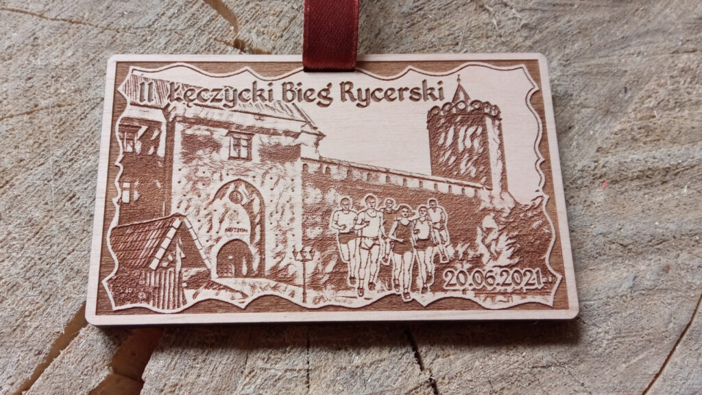 Prostokątny drewniany medal o solidnej grubości 6 mm na „Łęczycki Bieg Rycerski”, z precyzyjnym grawerem zamku oraz stylizowaną czcionką.