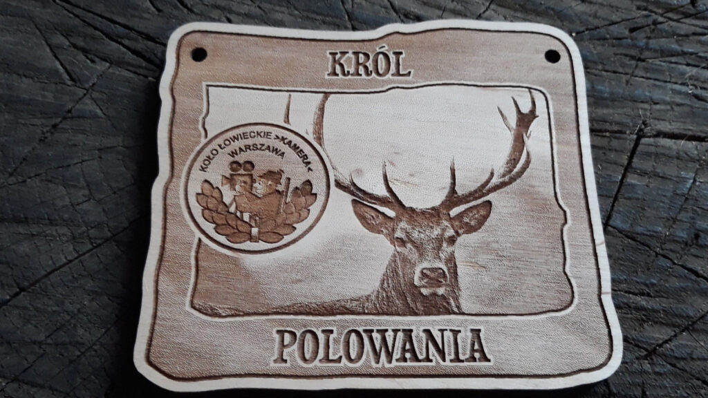 Prostokątny drewniany medal dla Króla Polowania z grawerem dumnego jelenia byka, napisem „Król Polowania” oraz miejscem na logotyp Koła Łowieckiego, wykonany z czystej brzozy bez osmaleń.