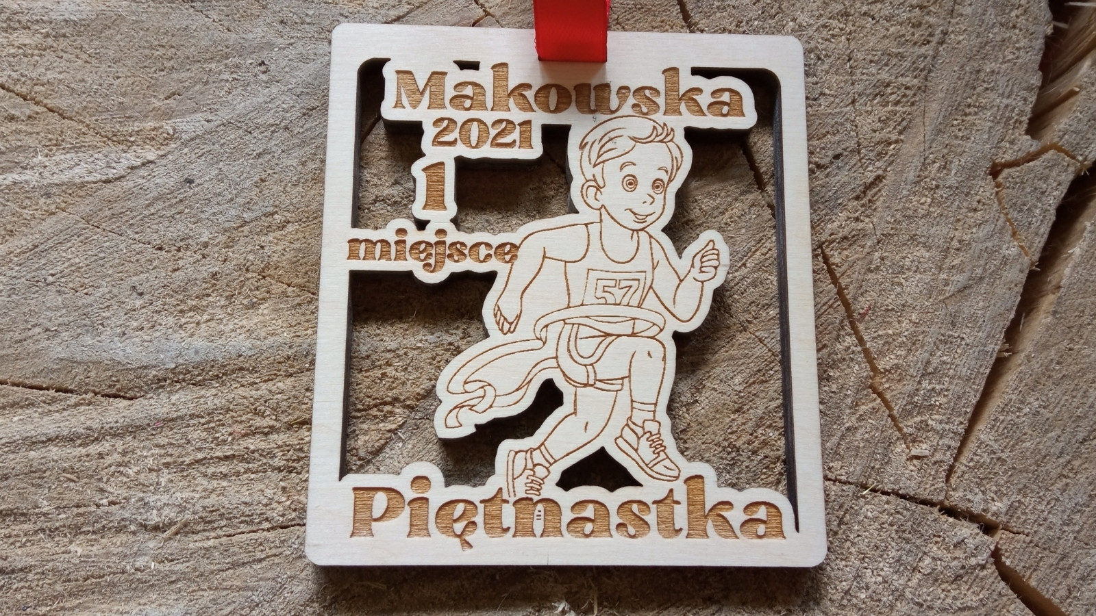 Makowska Piętnastka – drewniany medal z ażurowo wyciętym biegnącym chłopcem