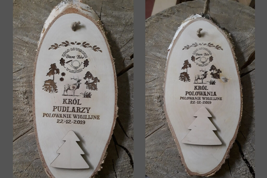 Dwa medale z naturalnych, skośnie ciętych plastrów drewna z korą; jeden dla Króla Polowania, drugi dla Króla Pudlarzy.