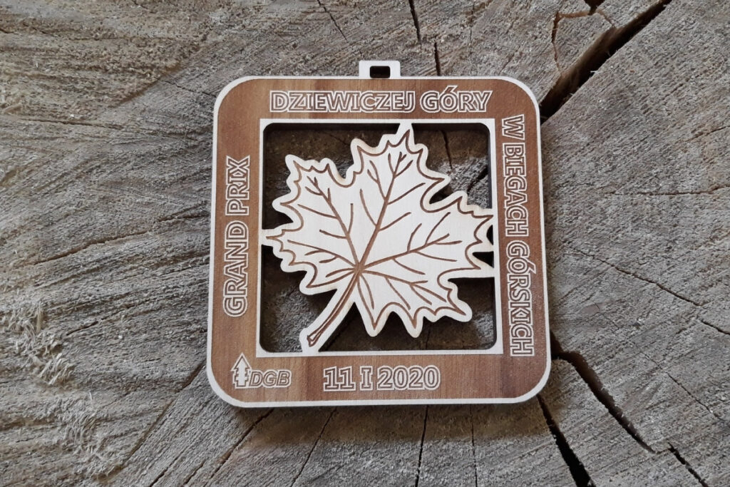 Kwadratowy drewniany medal z ażurowo wyciętym liściem