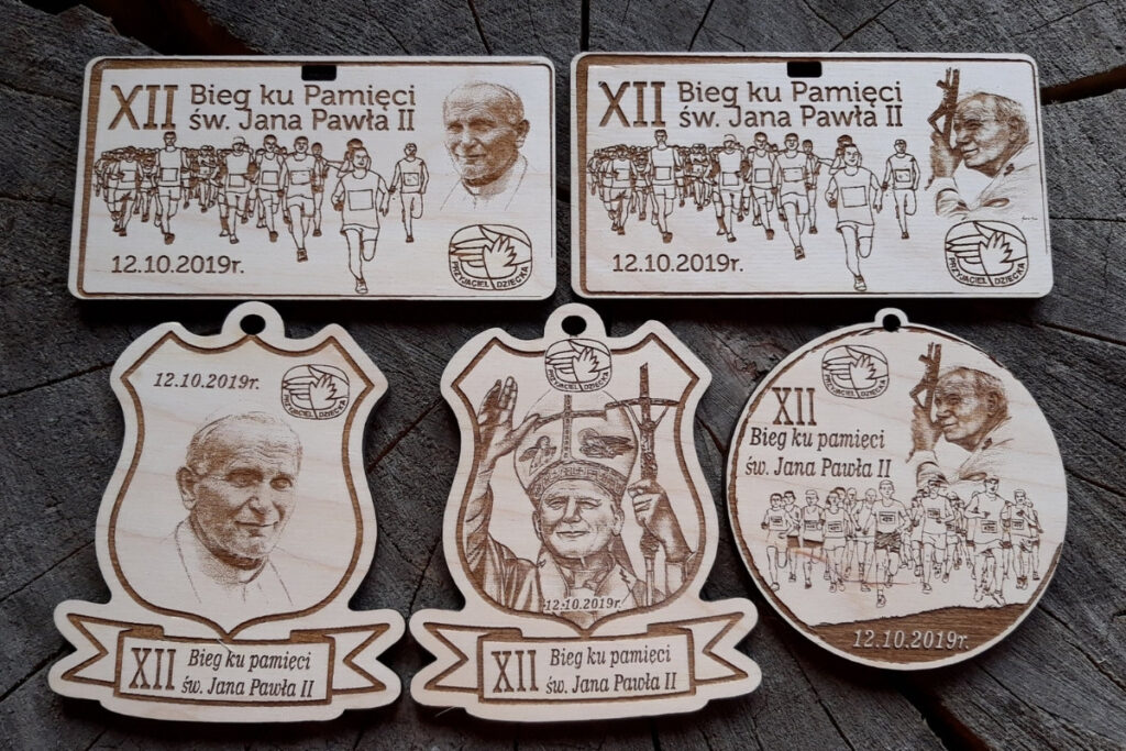 Projekty medali papieskich z drewna, medale na bieg Jana Pawła II, eko trofea religijne, pamiątka biegu papieskiego grawerowana, drewniane medale z wizerunkiem papieża.