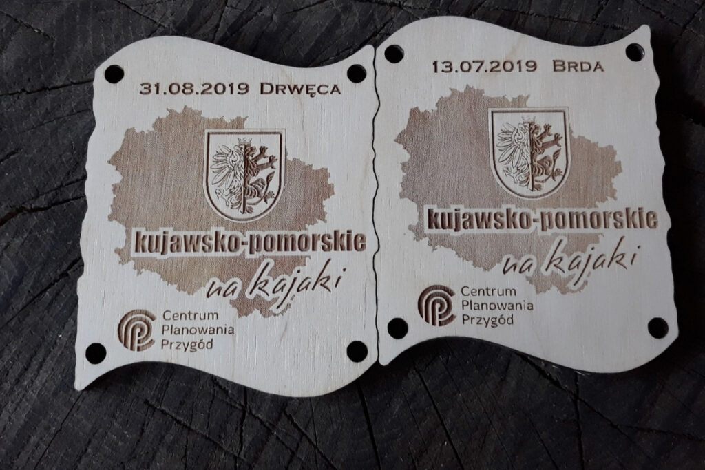 Zestaw dwóch drewnianych medali z grawerem mapy, które po złączeniu tworzą dopasowaną tabliczkę.