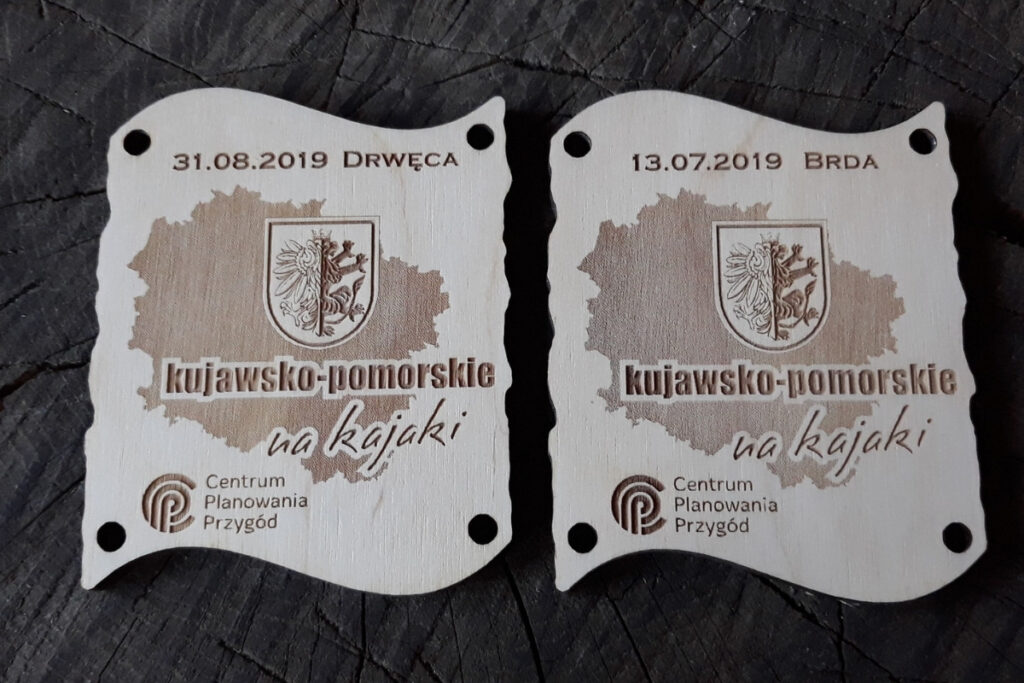 Zestaw dwóch drewnianych medali z grawerem mapy, które po złączeniu tworzą dopasowaną tabliczkę.