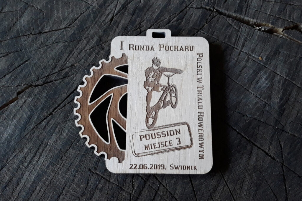Drewniany medal MTB z ażurowo wyciętą zębatką.
