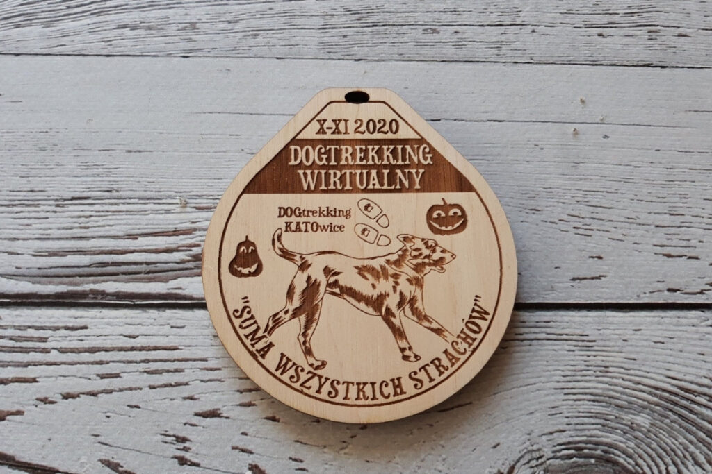 Drewniany medal na zawody Dogtrekking, z grawerem sylwetki psa oraz napisem „Dogtrekking”, wykonany z jasnej brzozy bez śladów dymu.