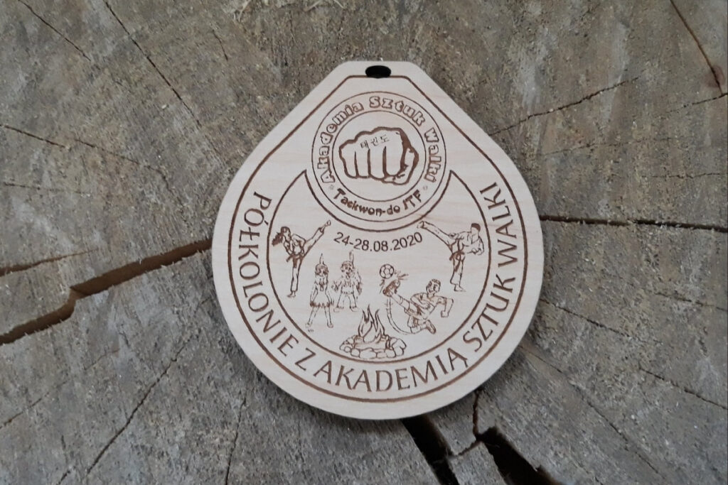 Drewniany medal pamiątkowy na półkolonie, z grawerem dzieci podczas różnych dyscyplin sportowych.