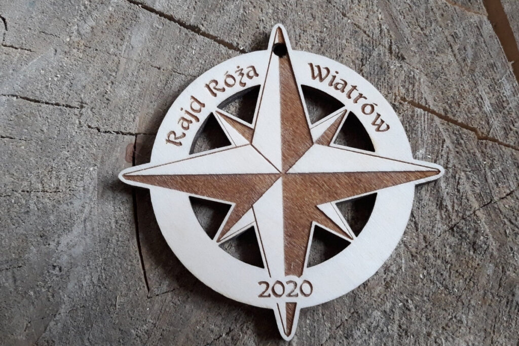 Rajd Róża Wiatrów – drewniany medal z ażurowo wyciętą różą wiatrów Rajd Róża Wiatrów – drewniany medal z ażurowo wyciętą różą wiatrów